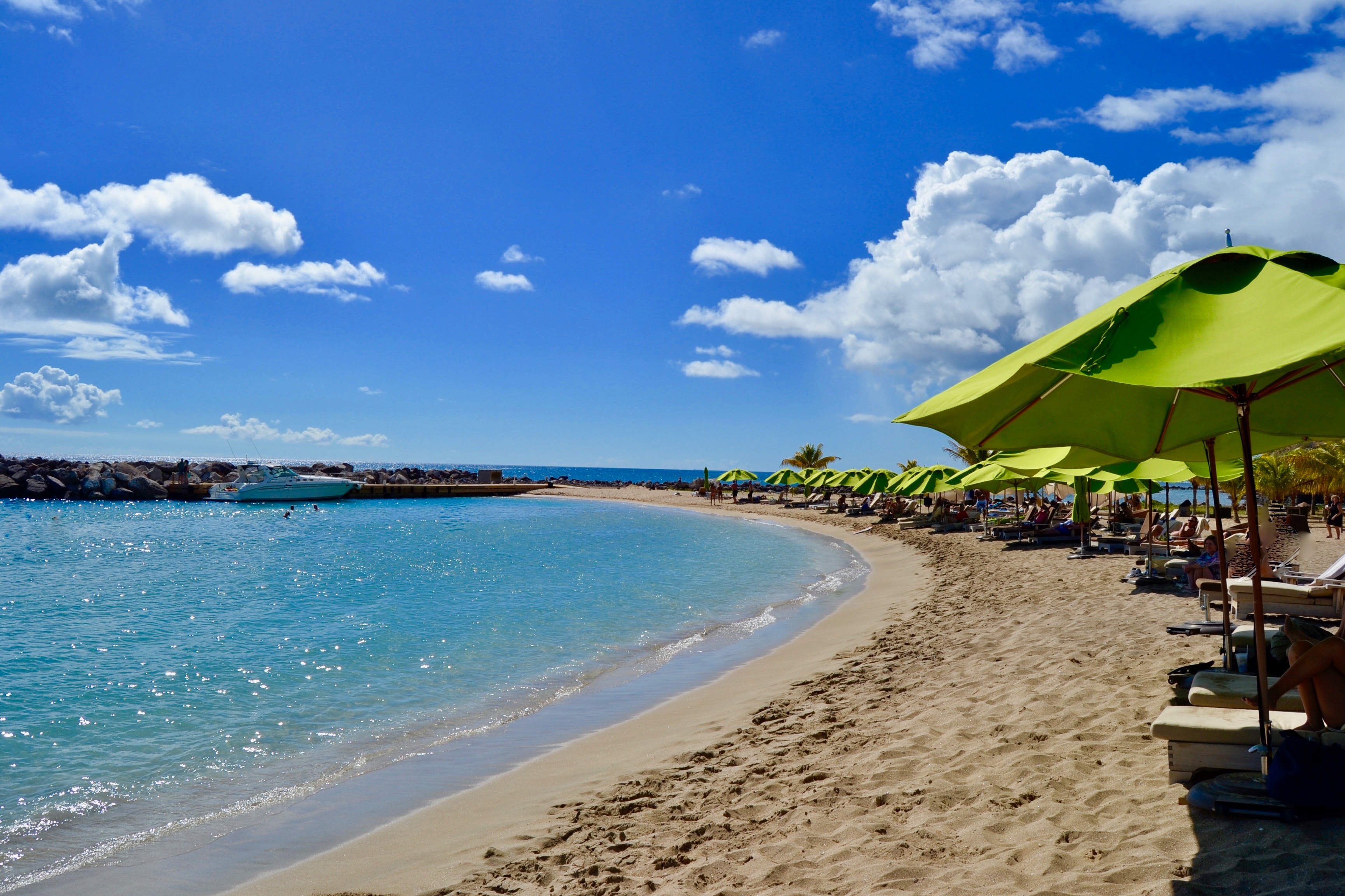 Beach with green umbrellas and sparkling turquoise water
