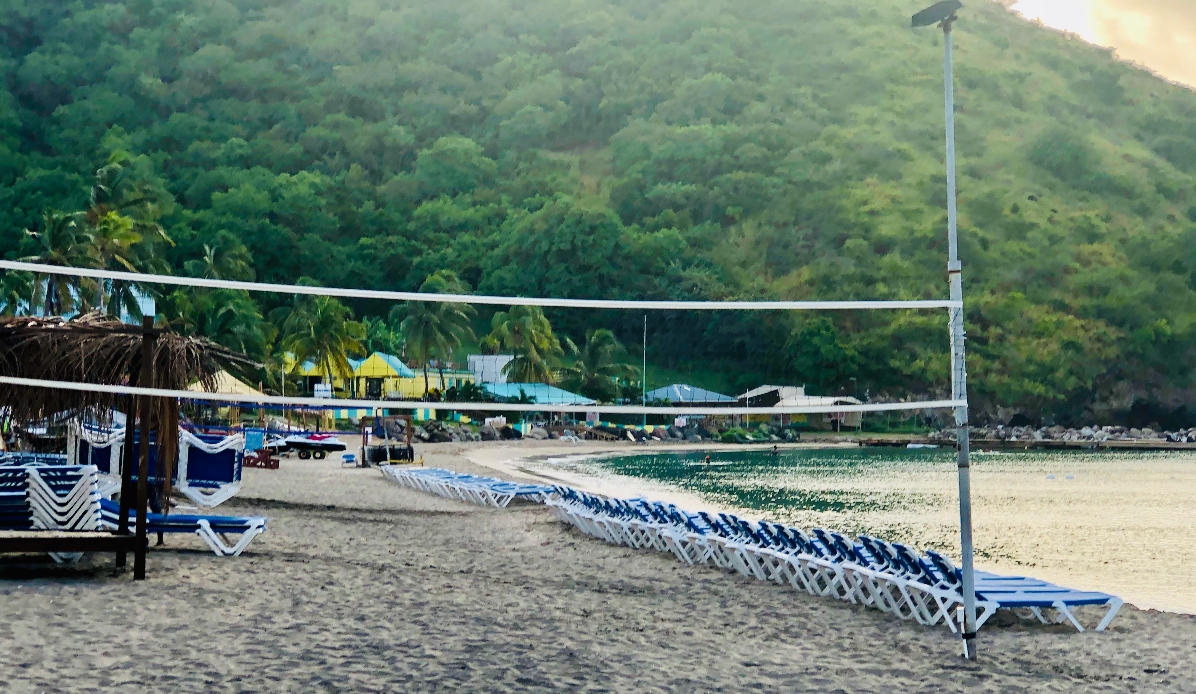Beach with lounge chairs and lush green mountains