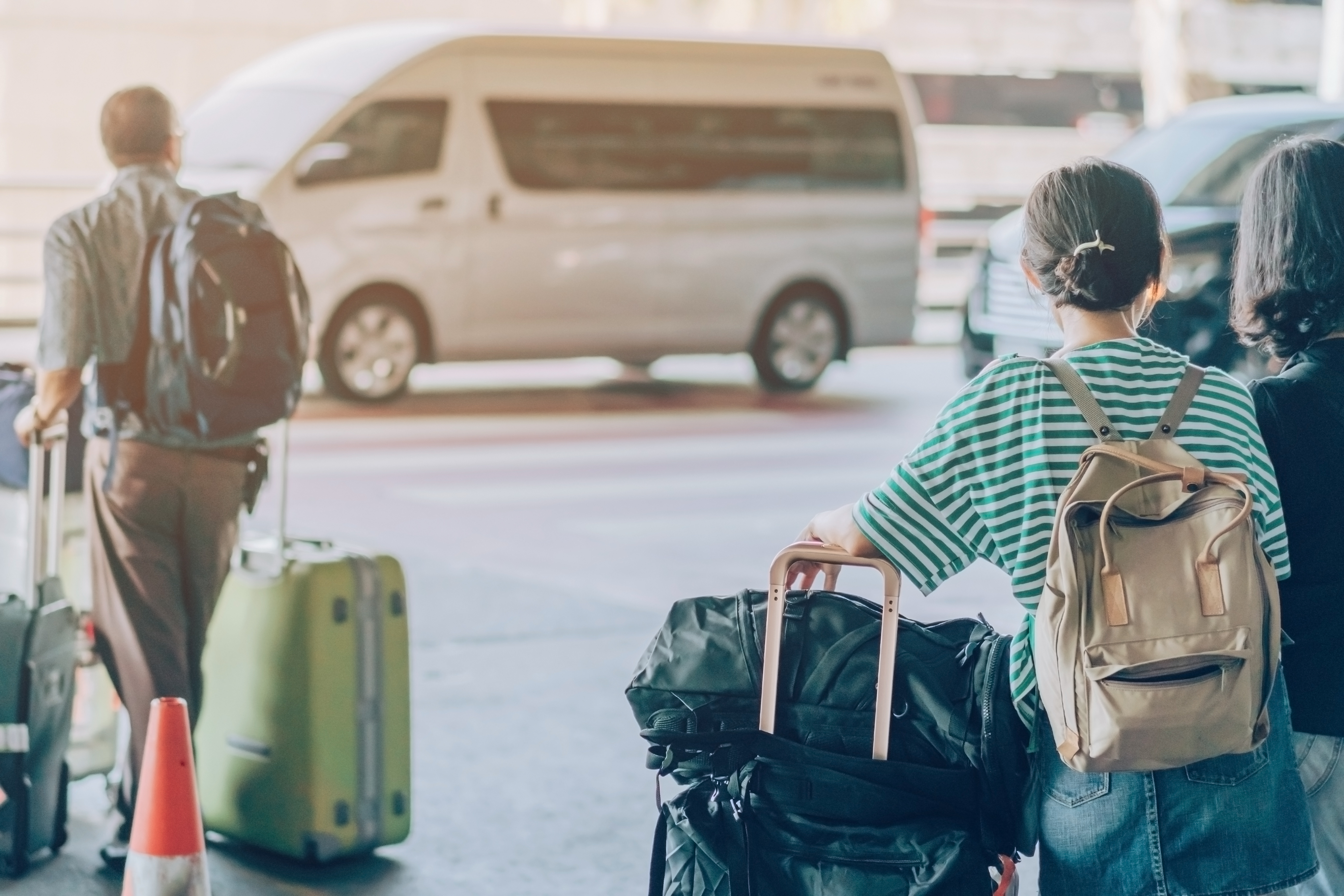 Travelers with luggage being picked up by private van transportation